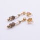 Freshwater Pearl, Smoky Quartz and Pyrite Gold Filled Earrings Freshwater Pearl, Smoky Quartz and Pyrite Gold Filled Earrings lying one above the other on a flat white surface