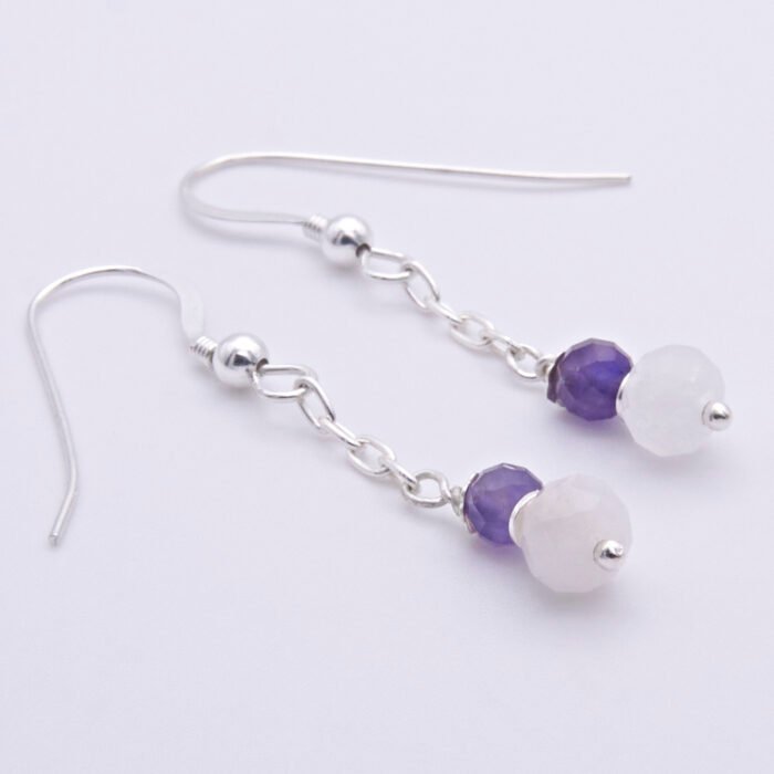 Amethyst and Rainbow Moonstone Sterling Silver Dangle Earrings laid flat on white surface