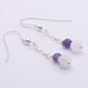 Amethyst and Rainbow Moonstone Sterling Silver Dangle Earrings laid flat on white surface