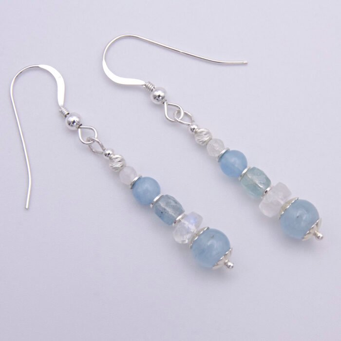 Aquamarine and Rainbow Moonstone Sterling Silver Earrings laid flat on white background