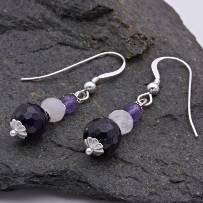 Amethyst, Rainbow Moonstone and Purple Banded Agate Stack Drop Sterling Silver Earrings shown sideways on laid flat on dark grey stone