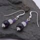 Amethyst, Rainbow Moonstone and Purple Banded Agate Stack Drop Sterling Silver Earrings shown sideways on laid flat on dark grey stone
