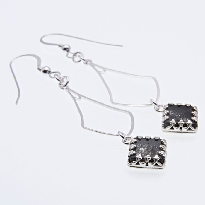 Tourmalinated Quartz Dangle Earrings lying flat on white surface showing side profile of bezel set stones