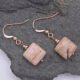 Zebra Jasper Rose Gold Filled Earrings shown from above on dark grey stone