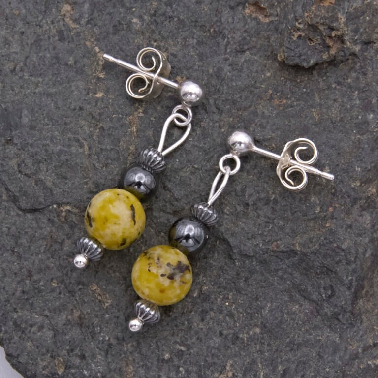 Yellow Turquoise and Hematite Sterling Silver dangles suspended from sterling silver stud ear posts with scroll backs, shown lying flat on grey stone