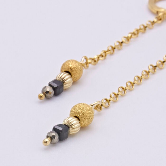 Black Spinel, Pyrite and Gold Vermeil Hinged Earhoop Dangles Black Spinel, Pyrite and Gold Vermeil Hinged Earhoop Dangles close up of bead stacks on flat white surface