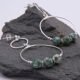 Green Spot Jasper Two-Hoop Sterling Silver Earrings showing both earrings on dark grey stone