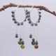 Yellow Turquoise and Hematite Wire-wrapped Hinged Hoop Dangle Sterling Silver Earrings shown hanging from twig