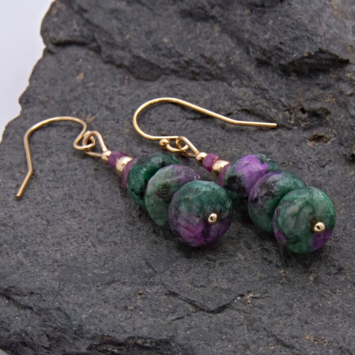 Ruby and Ruby Zoisite Gold Filled Stack Earrings viewed from the side, laid flat on dark grey stone