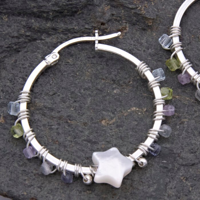 Mother of Pearl Star and mixed gemstone wire wrapped hinged hoop Sterling Silver Earrings Mother of Pearl Star and mixed gemstone wire wrapped hinged hoop Sterling Silver Earrings single earring laid on dark grey stone