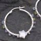 Mother of Pearl Star and mixed gemstone wire wrapped hinged hoop Sterling Silver Earrings Mother of Pearl Star and mixed gemstone wire wrapped hinged hoop Sterling Silver Earrings single earring laid on dark grey stone