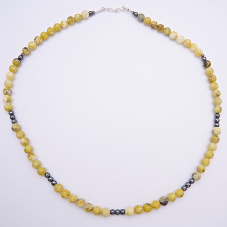 Yellow Turquoise and Hematite Gemstone Bead Necklace with Hook and Eye Clasp, shown from above on flat white surface