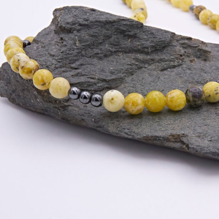 Yellow Turquoise and Hematite Bead Necklace close up of bead section on dark grey stone