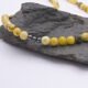 Yellow Turquoise and Hematite Bead Necklace close up of bead section on dark grey stone