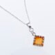 Carnelian Square Cabochon Sterling Silver Pendant Necklace angled close up of pendant and bail laid flat on a white surface