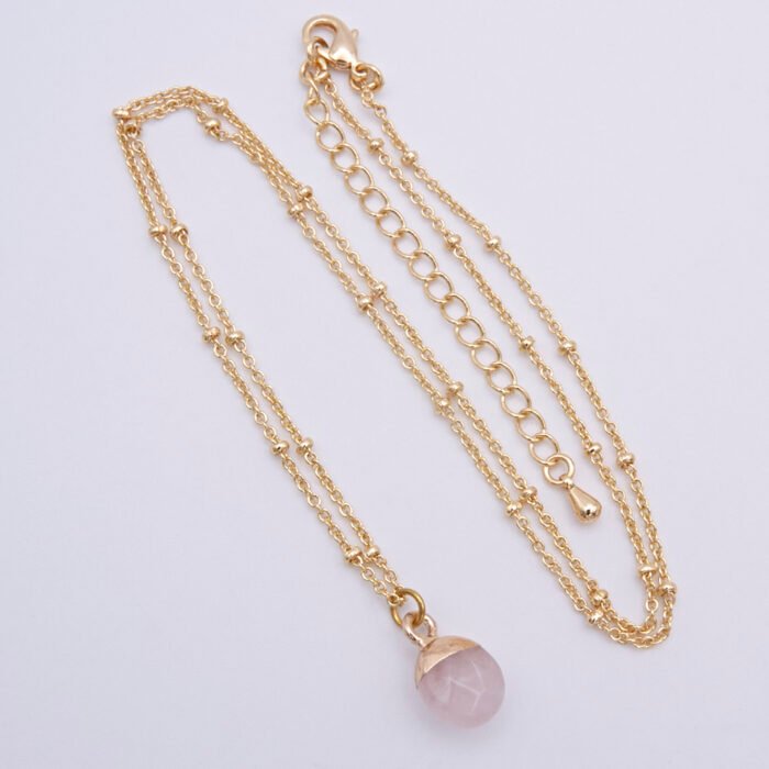 Rose Quartz Cabochon 24k gold plated silver pendant on gold plated satellite chain Rose Quartz Cabochon 24k gold plated silver pendant on gold plated satellite chain shown from above on flat white surface