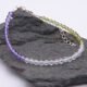 Genderqueer Flag Colours Amethyst, Crystal Quartz and Peridot Gemstone Bracelet with Sterling Silver clasp and extender chain, shown from the side, laid on a dark grey stone