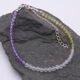 Genderqueer Flag Colours Gemstone Bracelet in Amethyst, Crystal Quartz and Peridot, with Sterling Silver clasp and extender chain, shown laid flat on a dark grey stone