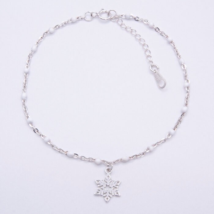 Sterling Silver and White Enamel Bead Bracelet with Sterling Silver Snowflake Charm shown viewed from above on plain white background
