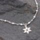 Sterling Silver and White Enamel Bead Bracelet with Sterling Silver Snowflake Charm shown laid flat on dark grey stone with close up of snowflake and part of chain