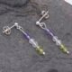 Sterling Silver Stud Earrings with Mixed Gemstone Dangles in Amethyst, Crystal Quartz and Peridot shown laid flat on dark grey stone