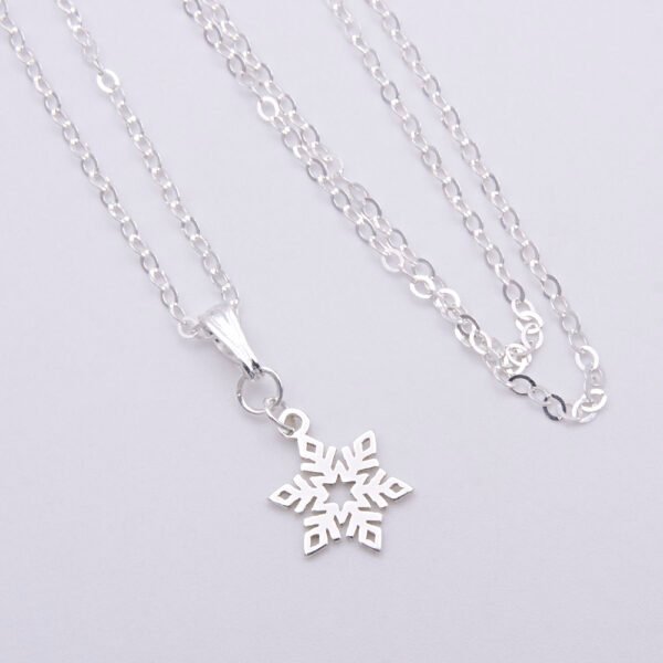 Sterling Silver Snowflake Charm suspended from a Sterling Silver chain via a small decorative bail, image shows charm, bail and chain laid flat on plain white background