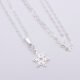 Sterling Silver Snowflake Charm suspended from a Sterling Silver chain via a small decorative bail, image shows charm, bail and chain laid flat on plain white background