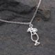 Sterling Silver Cocktail Charm Pendant Necklace, close up of cocktail charm and part of chain on dark grey stone, cocktail charm is at a slight angle