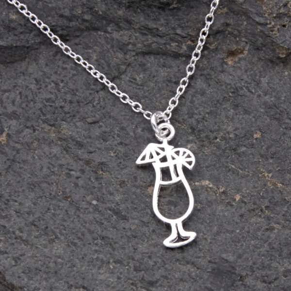 Sterling Silver Cocktail Charm suspended from a Sterling Silver chain, image shows close-up of cocktail and small portion of chain, laid flat on dark grey stone