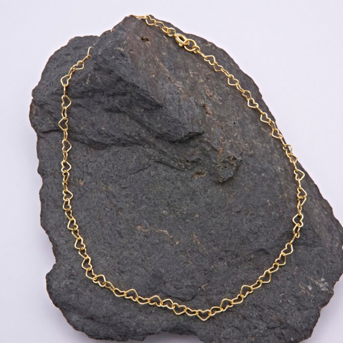 Gold Filled Heart Link Chain Anklet shown from above on dark grey stone