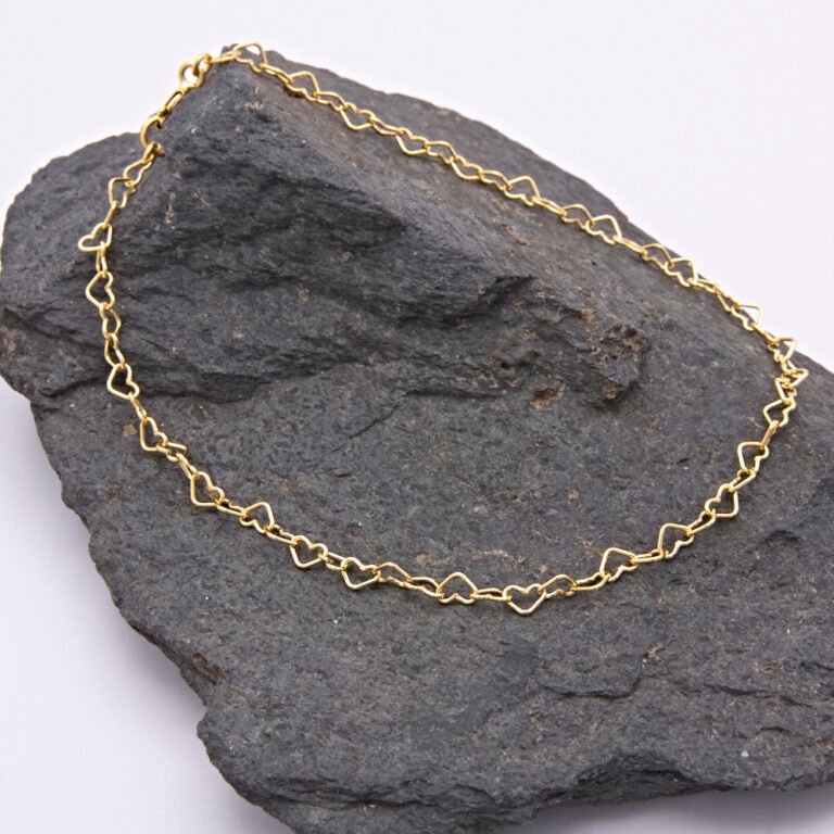 Gold Heart Link Chain Bracelet shown on dark grey stone