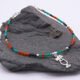 Green Onyx, Carnelian and Sapphire Sterling Silver Bracelet with Sterling Silver Cocktail Charm in the centre, image shows bracelet draped at an angle over dark grey stone, with charm slightly to the right