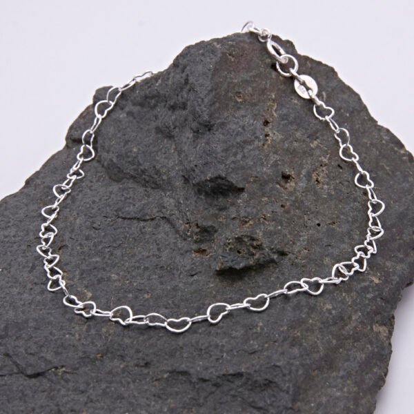 Sterling Silver Heart Link Chain Bracelet with spring clasp shown displayed on dark grey stone