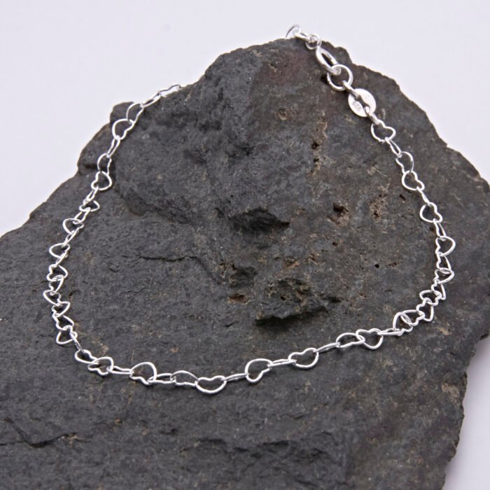 Sterling Silver Heart Link Chain Bracelet with spring clasp shown displayed on dark grey stone