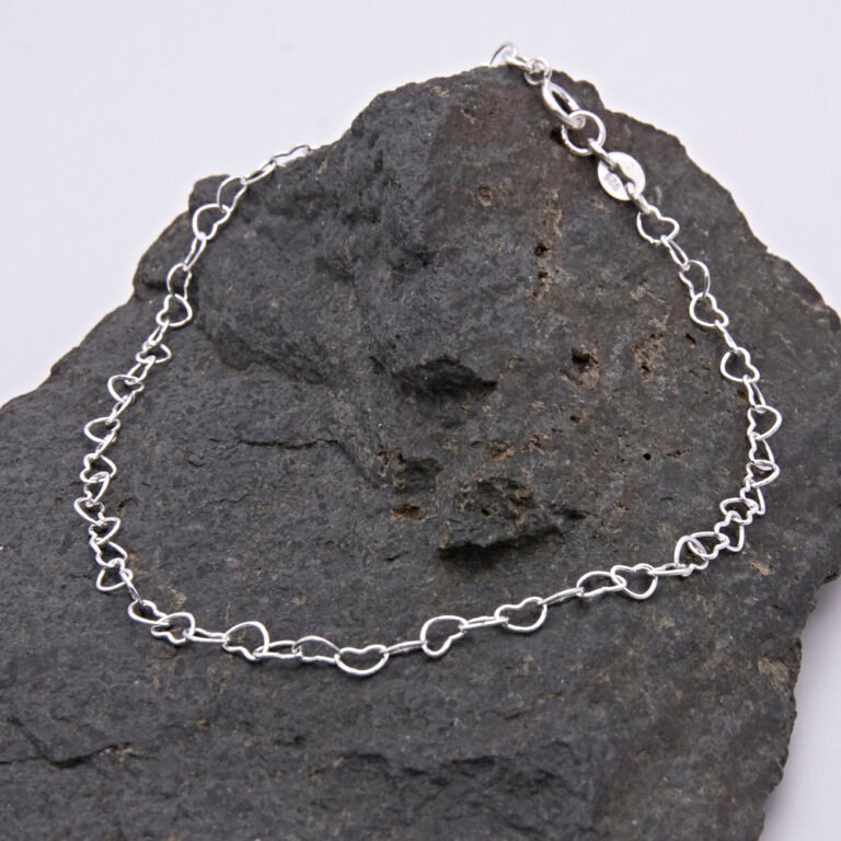 Sterling Silver Heart Link Chain Bracelet with spring clasp shown displayed on dark grey stone