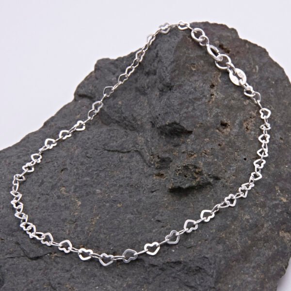 Sterling Silver Tiny Heart Link Chain Bracelet displayed on dark grey stone