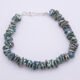 Green Keishi Cornflake Freshwater Pearl and Sterling Silver Bracelet, shown viewed from above on plain white surface, with clasp at the top of the image