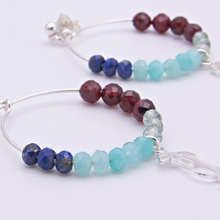 Mixed Gemstone Sterling Silver Hoop Earrings with Cocktail Charms shown laid flat on plain white surface, viewed close up from the side