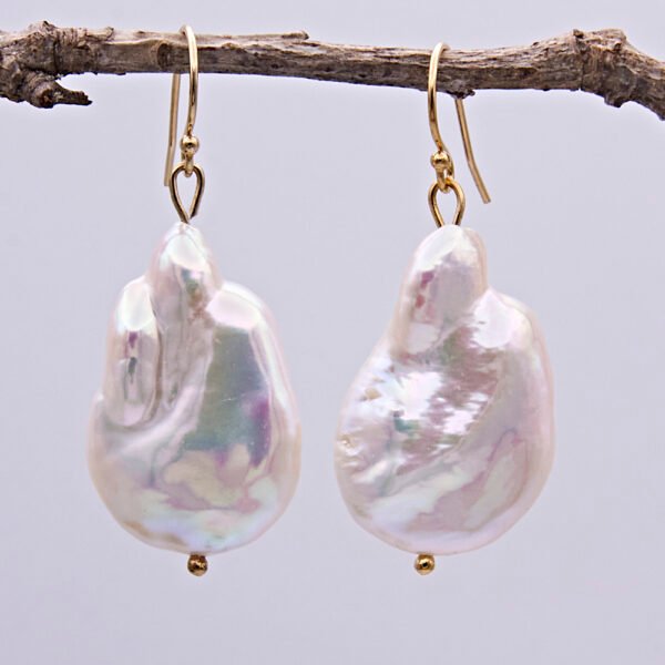 Baroque pear-shaped Freshwater Pearl Earrings shown hanging from twig