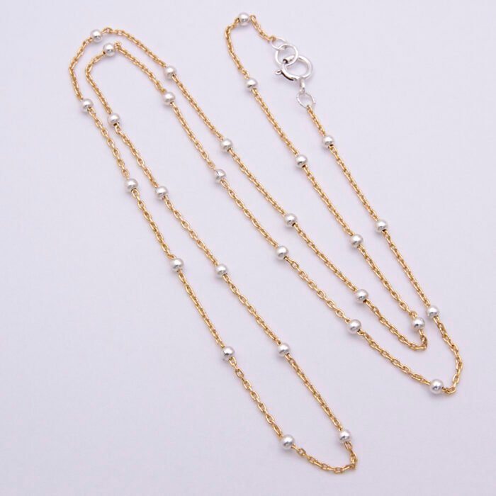 Gold Filled and Sterling Silver Satellite Chain Necklace, shown from above and flat white surface