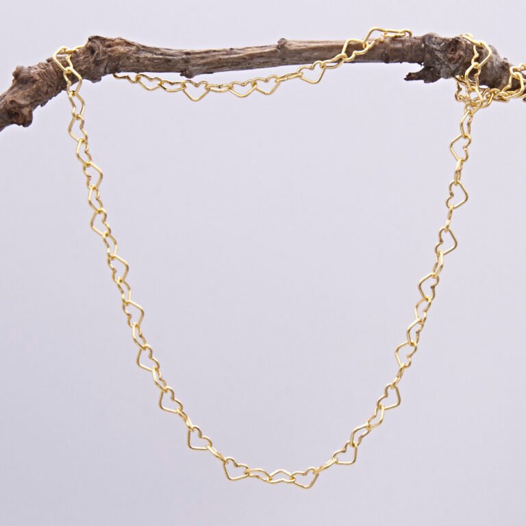 Gold Heart Link Chain Necklace shown hanging from a twig