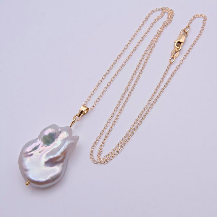 Baroque pear-shaped Freshwater Pearl Necklace shown laid flat on plain white background with chain in loose N shape