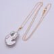 Baroque pear-shaped Freshwater Pearl Necklace shown laid flat on plain white background with chain in loose N shape