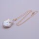 Baroque pear-shaped Freshwater Pearl Necklace shown on flat white surface with pearl at the bottom of the image and chain looped in a loose N shape
