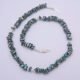 Green Keishi Cornflake Freshwater Pearl and Sterling Silver Necklace, image shows necklace unfastened, in a loose spiral, on plain white background, viewed from above