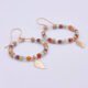Gold Filled Gemstone Hoop Earrings with Gold Leaf Charm, viewed from the side on plain white background