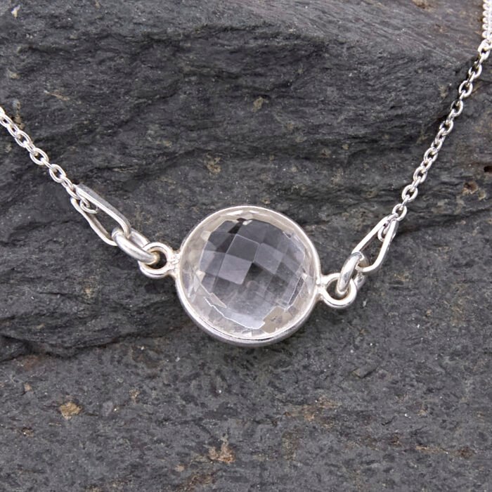 Smoky Quartz or Crystal Quartz round bezel set faceted gemstone Sterling Silver necklace Smoky Quartz or Crystal Quartz round bezel set faceted gemstone Sterling Silver necklace, images shows close-up of Crystal Quartz gemstone on dark stone
