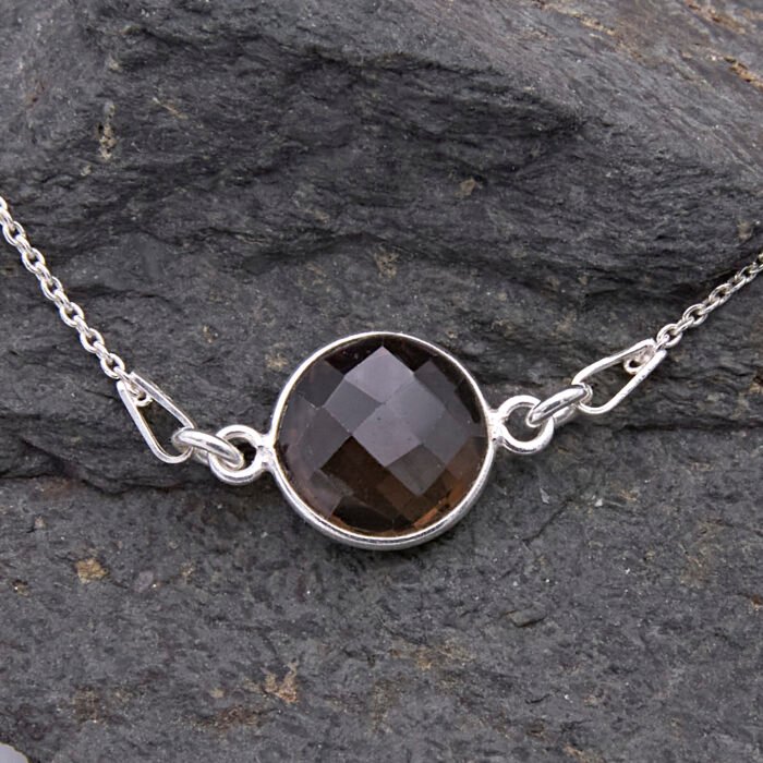 Smoky Quartz or Crystal Quartz round bezel set faceted gemstone Sterling Silver necklace Smoky Quartz or Crystal Quartz round bezel set faceted gemstone Sterling Silver necklace, image shows close-up of Smoky Quartz gemstone on dark grey stone