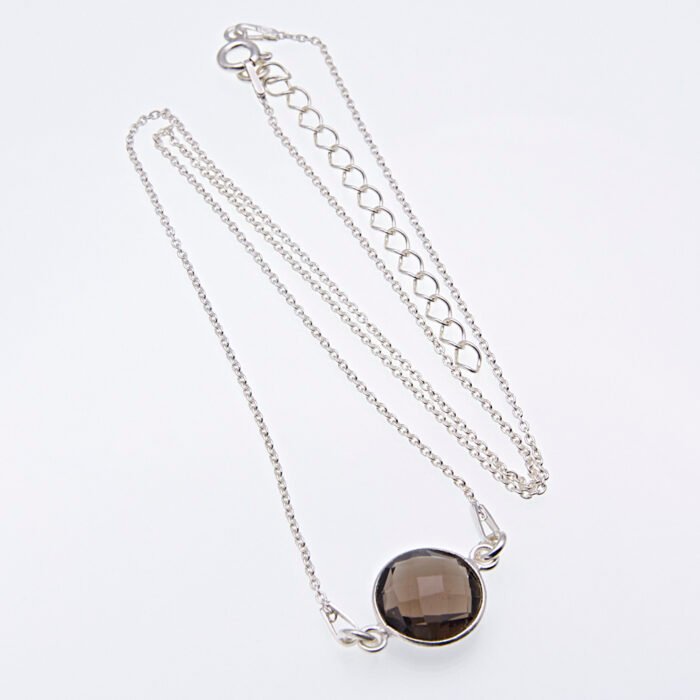 Smoky Quartz or Crystal Quartz round bezel set faceted gemstone Sterling Silver necklace Smoky Quartz or Crystal Quartz round bezel set faceted gemstone Sterling Silver necklace, image shows Smoky Quartz necklace from above on plain white background with stone at the bottom of the image