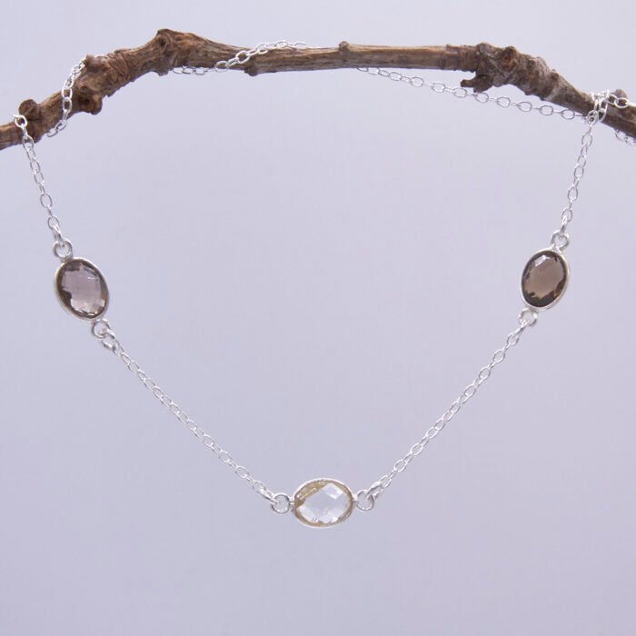 Smoky Quartz and Crystal Quartz 3-stone bezel-set Necklace on Sterling Silver Chain, shown hanging from twig